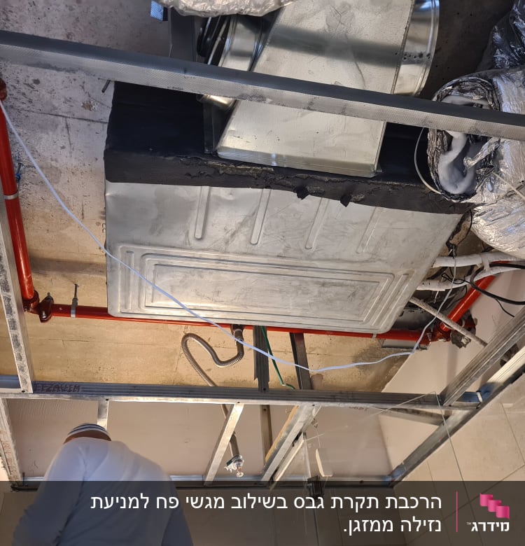תקרת גבס עם צינורות אדומים ומערכת אוורור